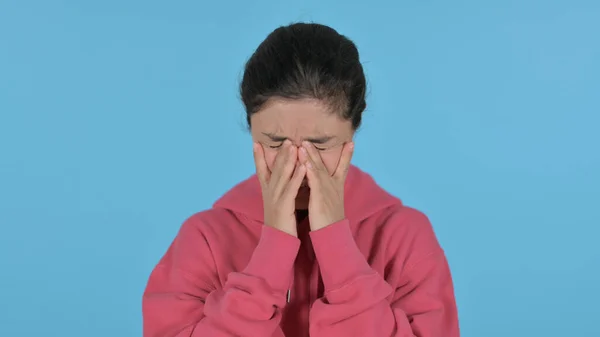 Indian Girl Looking at the Camera, Sad Expression, Blue Background — стокове фото