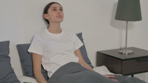 Mujer hispana molesta sintiéndose preocupada mientras está sentada en la cama — Vídeos de Stock