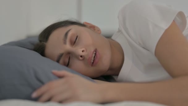 Hispanische Frau hat Kopfschmerzen, während sie im Bett schläft, in Seitenlage — Stockvideo