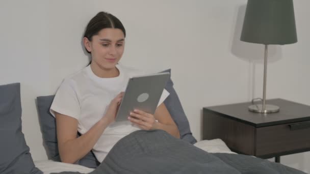 Donna ispanica utilizzando Tablet mentre seduto a letto — Video Stock
