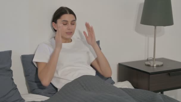 ベッドに座っている間に頭痛を持っているヒスパニック系女性 — ストック動画