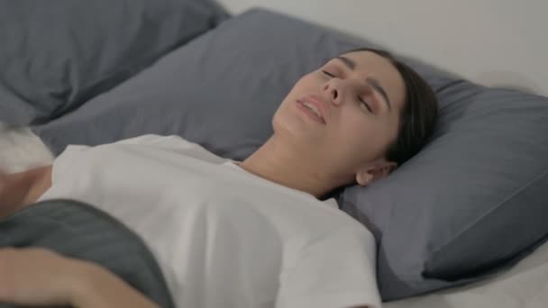 Ισπανίδα γυναίκα που έχει πονοκέφαλο ενώ κοιμάται στο κρεβάτι — Αρχείο Βίντεο