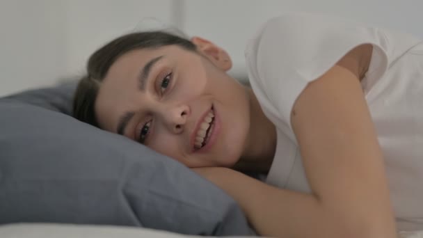 ベッドで寝ている間にビデオ通話で話すヒスパニック系女性,サイドポーズ — ストック動画