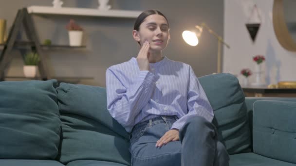 Hispanische Frau hat Nackenschmerzen, während sie auf dem Sofa sitzt — Stockvideo