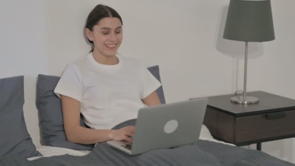 Donna ispanica che fa videochiamata sul computer portatile a letto — Video Stock