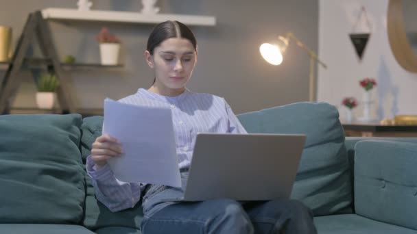 Hispanic Woman with Laptop Working on Documents on Sofa — стокове відео