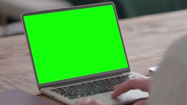 Hombre joven usando el ordenador portátil con pantalla verde — Vídeos de Stock
