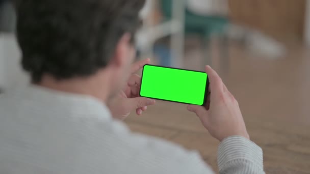 Jongeman op zoek naar Smartphone met Chroma Screen — Stockvideo