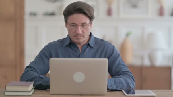 Jeune homme travaillant sur ordinateur portable au bureau — Video