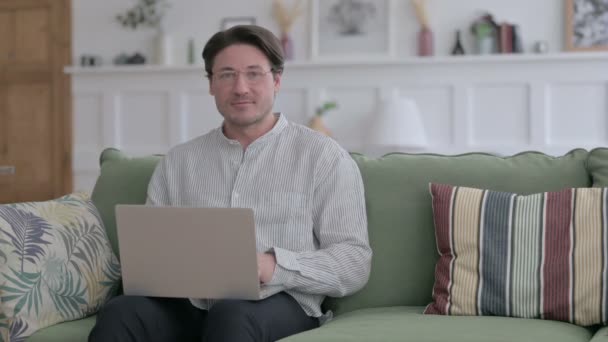 Koltukta dizüstü bilgisayar kullanırken İşaret İşareti Gösteren Genç Adam — Stok video