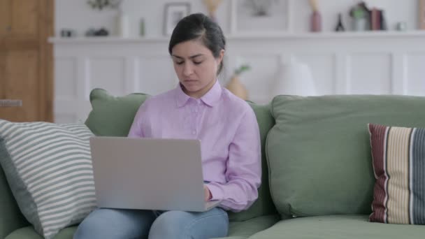 Femme indienne ayant la douleur au poignet tout en utilisant un ordinateur portable sur le canapé — Video