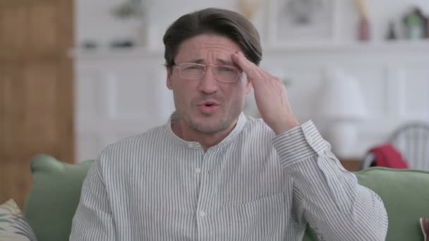 Porträtt av ung man med huvudvärk hemma — Stockvideo