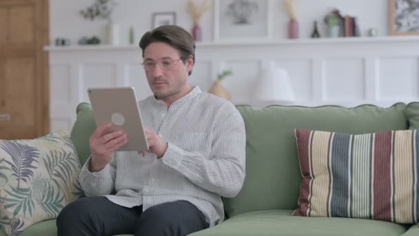 Giovane uomo che utilizza Tablet su divano — Video Stock