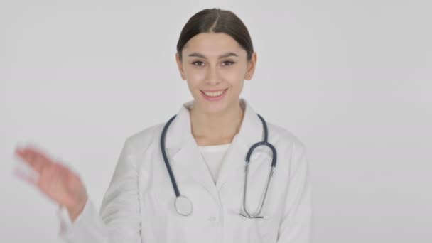 Willkommene spanische Ärztin winkt auf weißem Hintergrund — Stockvideo