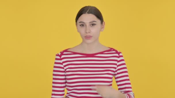 Mulher espanhola apontando para o produto no fundo amarelo — Vídeo de Stock