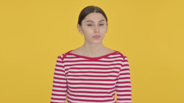 黄色の背景に拒絶反応で頭を振るスペイン人女性 — ストック動画