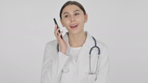 Испанская женщина-врач разговаривает по телефону на белом фоне — стоковое видео