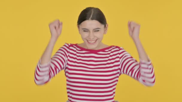 Mulher espanhola entusiasmada comemorando o sucesso em fundo amarelo — Vídeo de Stock