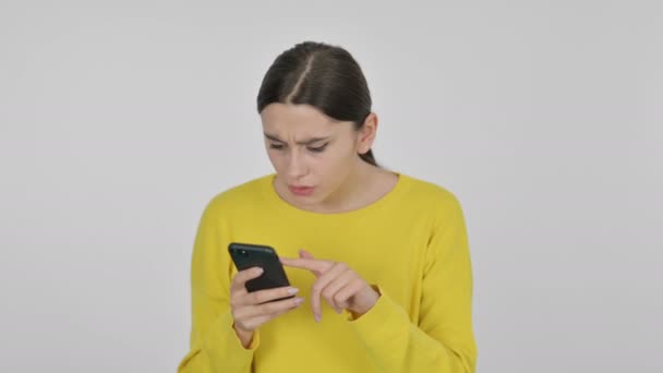 Spanska kvinna som reagerar på förlust på smartphone på vit bakgrund — Stockvideo