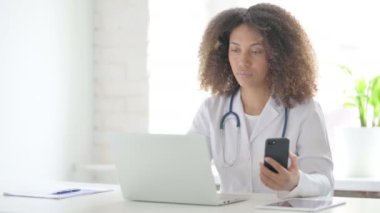 Afrcian Doctor Klinikte dizüstü bilgisayar kullanırken Smartphone kullanıyor 