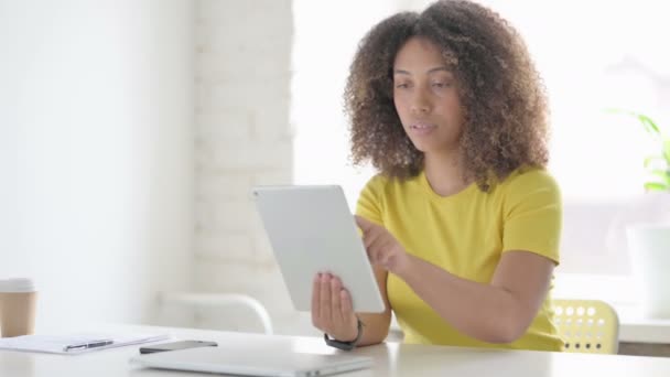 Mujer africana usando Tablet mientras está sentada en la oficina — Vídeos de Stock
