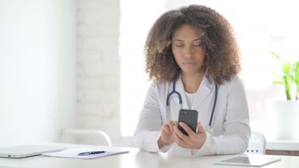 Médico africano usando Smartphone en Clínica — Vídeos de Stock