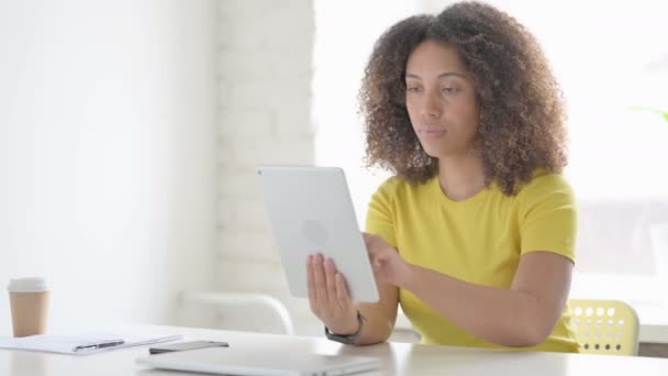 Mujer africana haciendo videollamada en la tableta en la oficina — Vídeos de Stock