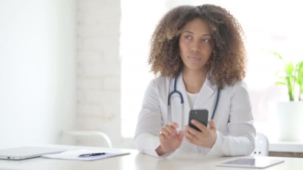Afrcian Lekarz rozmawiający przez telefon w klinice — Wideo stockowe