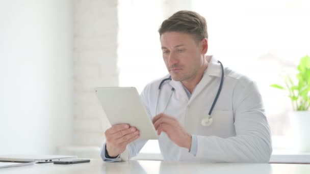 Médico masculino usando Tablet enquanto sentado no escritório — Vídeo de Stock