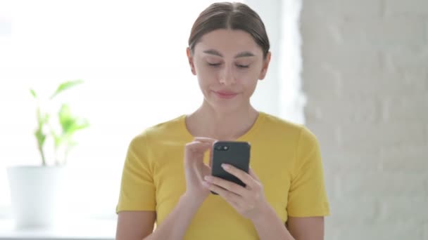 Portrett av en kvinne som reagerer på tap på smarttelefon – stockvideo