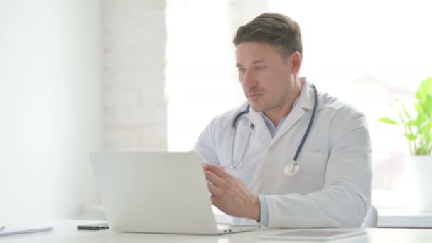 Manlig doktor talar på video samtal på laptop i Office — Stockvideo