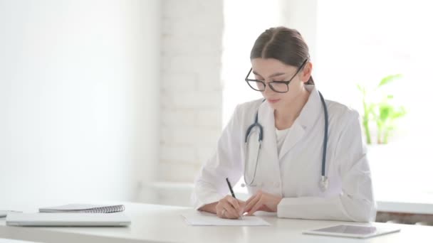 Ärztin schreibt im Büro auf Papier — Stockvideo