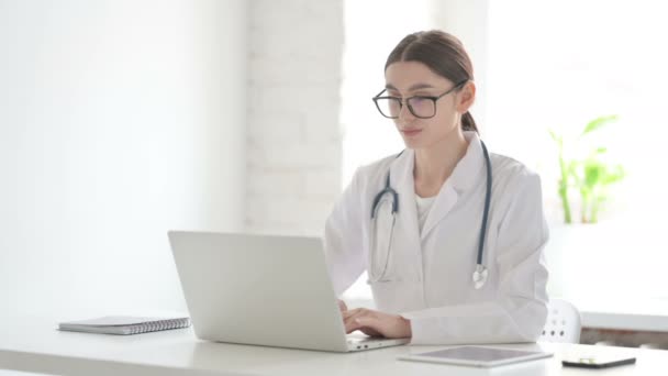 Vrouwelijke arts praten op video bellen op laptop in Office — Stockvideo