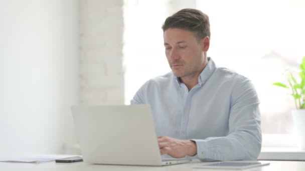 Человек, работающий над ноутбуком в офисе — стоковое видео