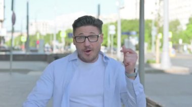 Orta yaşlı adam dışarıda dans ediyor, heyecanlı hissediyor.