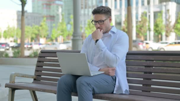 Denkender Mann Mittleren Alters Benutzt Laptop Während Draußen Auf Bank — Stockvideo