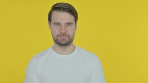 黄色の背景にサイドを指すカジュアル若い男 — ストック動画