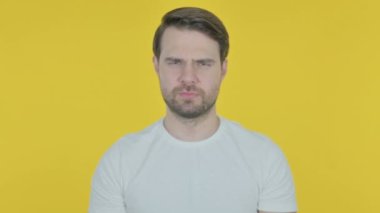 Rejecting Casual Young Man with Arm Gesture on Yellow Background 