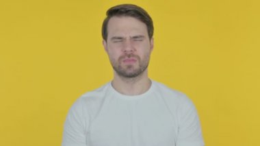 Sarı arka planda boyun ağrısı ile Casual genç adam 