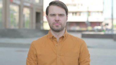Casual Young Man Looking at the Camera Outdoor