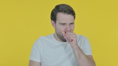 Rahat genç adam sarı arka planda öksürük 