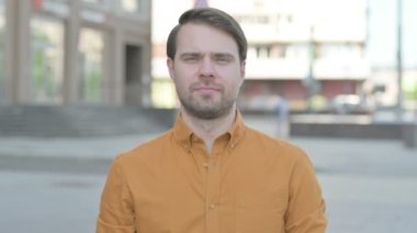 Casual Young Man Smiling at Camera Outdoor