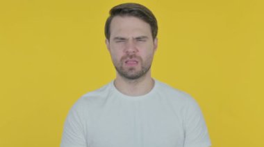 Sarı arka plan üzerinde baş ağrısı ile Casual genç adam 