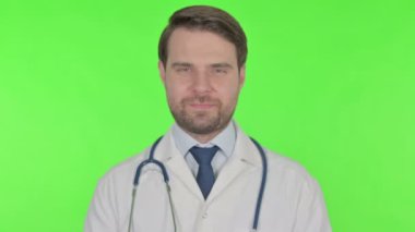 Smiling Young Adult Doctor on Green Background 