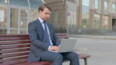 Young Businessman Leaving Bench after Closing Laptop