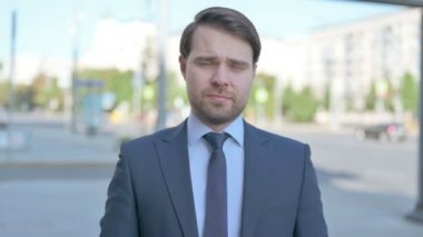 Rejecting Middle Aged Businessman Shaking Head in Denial Outdoor