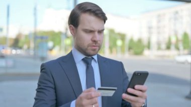 Excited Middle Aged Businessman Shopping Online via Smartphone, Outdoor