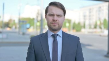 Rejecting Middle Aged Businessman Shaking Head in Denial Outdoor