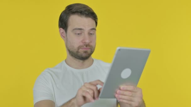 Casual Jonge Man Viert Succes Tablet Gele Achtergrond — Stockvideo
