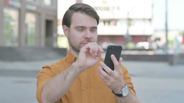 Upset Casual Young Man Reacting Loss Smartphone Outdoor — Vídeos de Stock